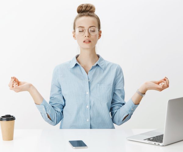 personne méditant face à un ordinateur, un téléphone et un café